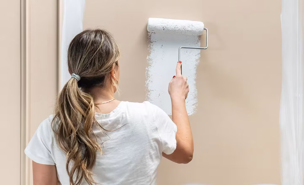 a girl painting a wall